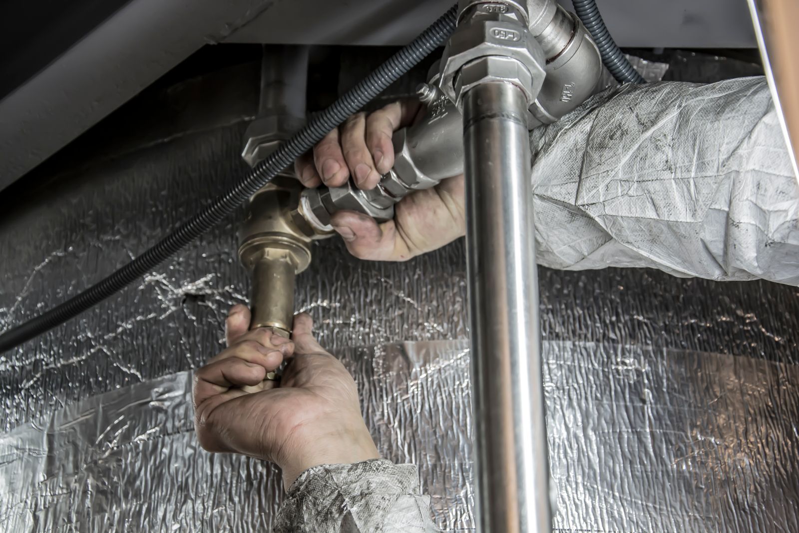 Emergency plumber in Manchester A plumber repairing pipe fittings in Manchester